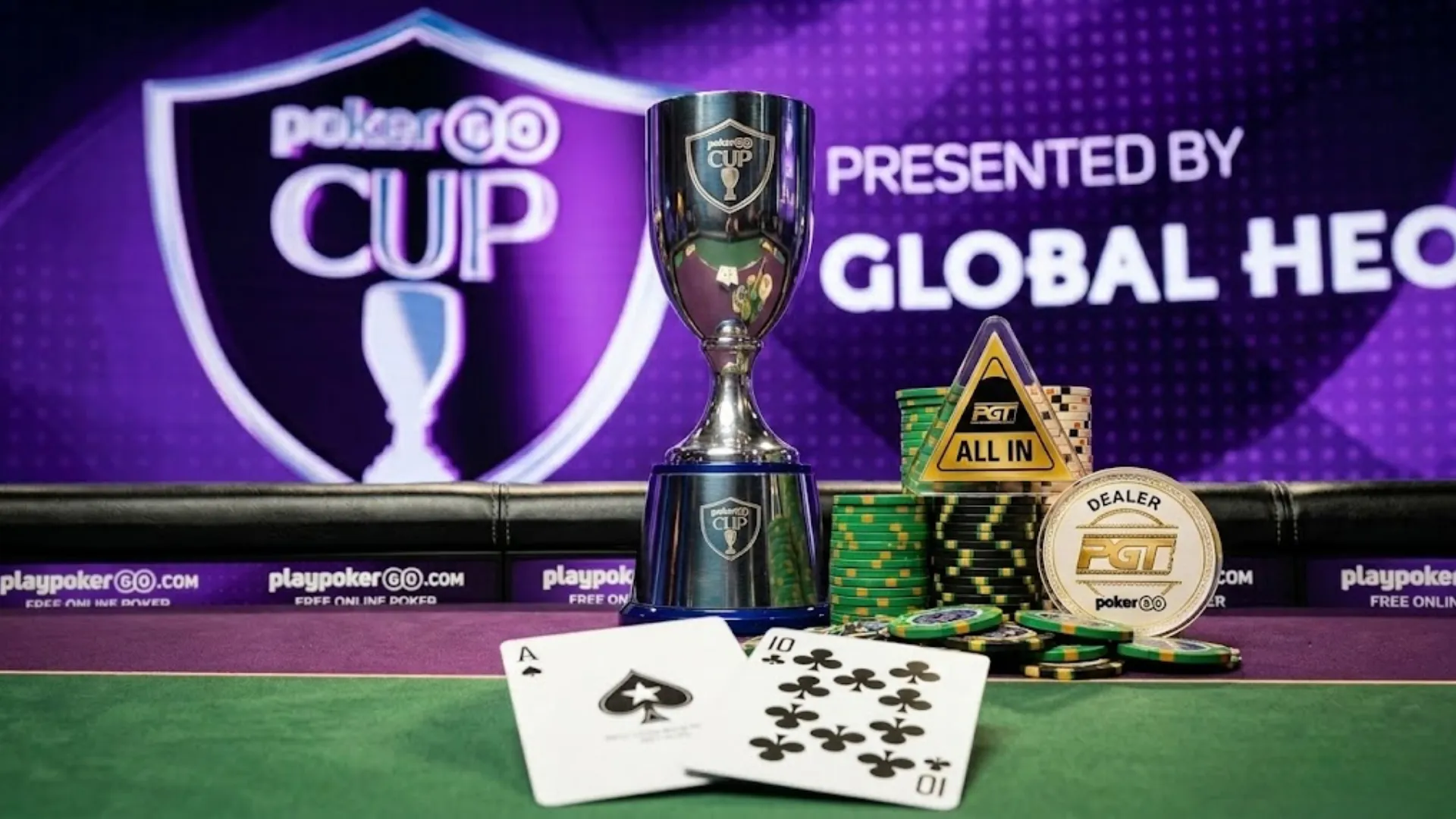 PokerGO Cup獎盃搭配梅花A與梅花10、籌碼、PGT全下按鈕及莊家幣，陳列於最終桌桌面